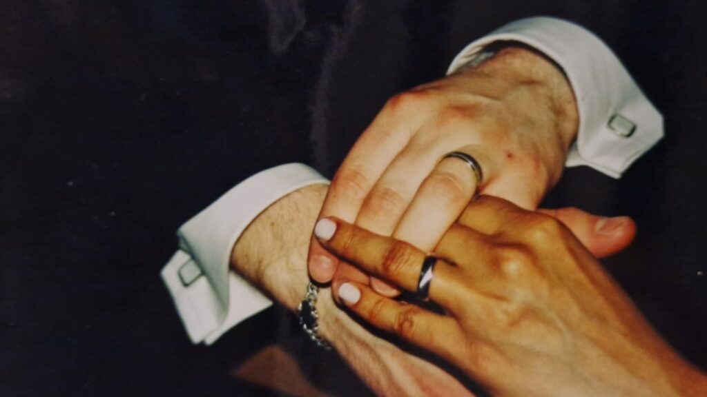 Intertwined hands with wedding rings — a symbol of love in a multicultural marriage.